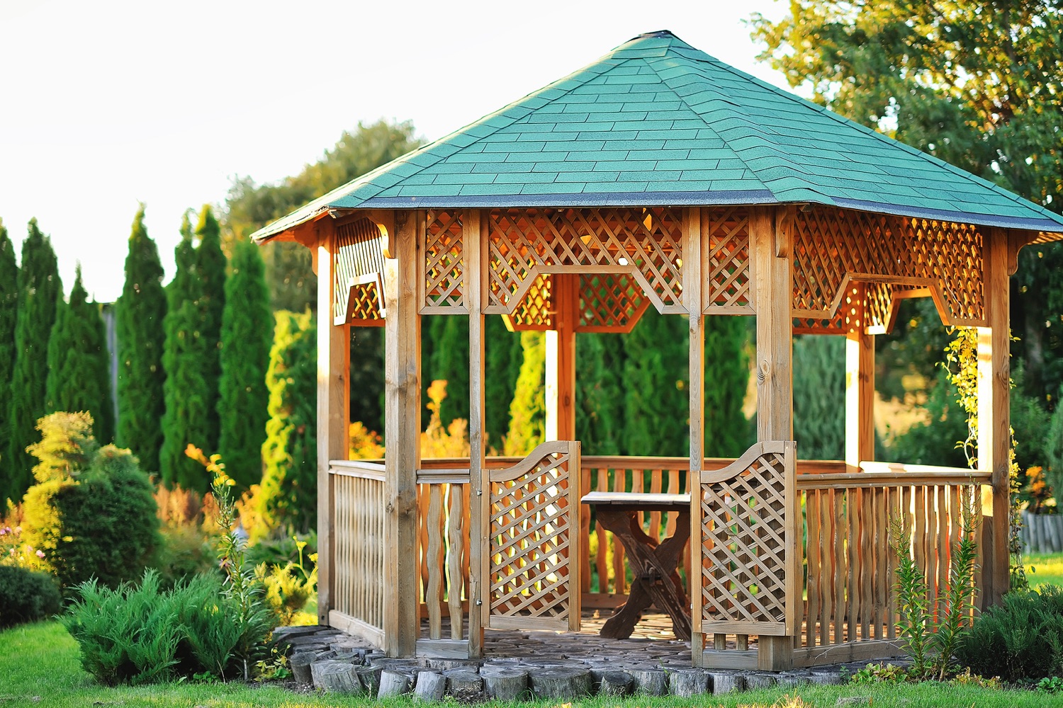 A picture of a beautiful gazebo with bench in a scenic sunny area.